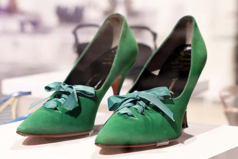 Closeup of vintage green suede shoes with grosgrain lace-up bow detail.