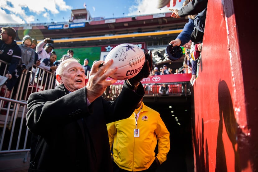Dallas Cowboys owner Jerry Jones signs autographs for fans before an NFL game between the...