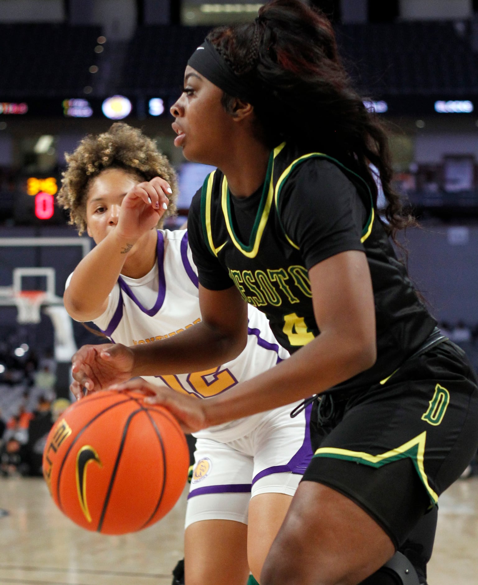 DeSoto senior Ja'Mia Harris (4), right, drives the baseline as she is defended by Montverde...