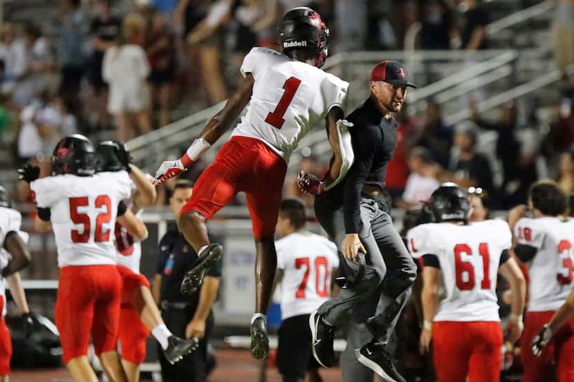 Liberty High School wide receiver Kamryn Smith (1) leaps to congratulate a coach after...