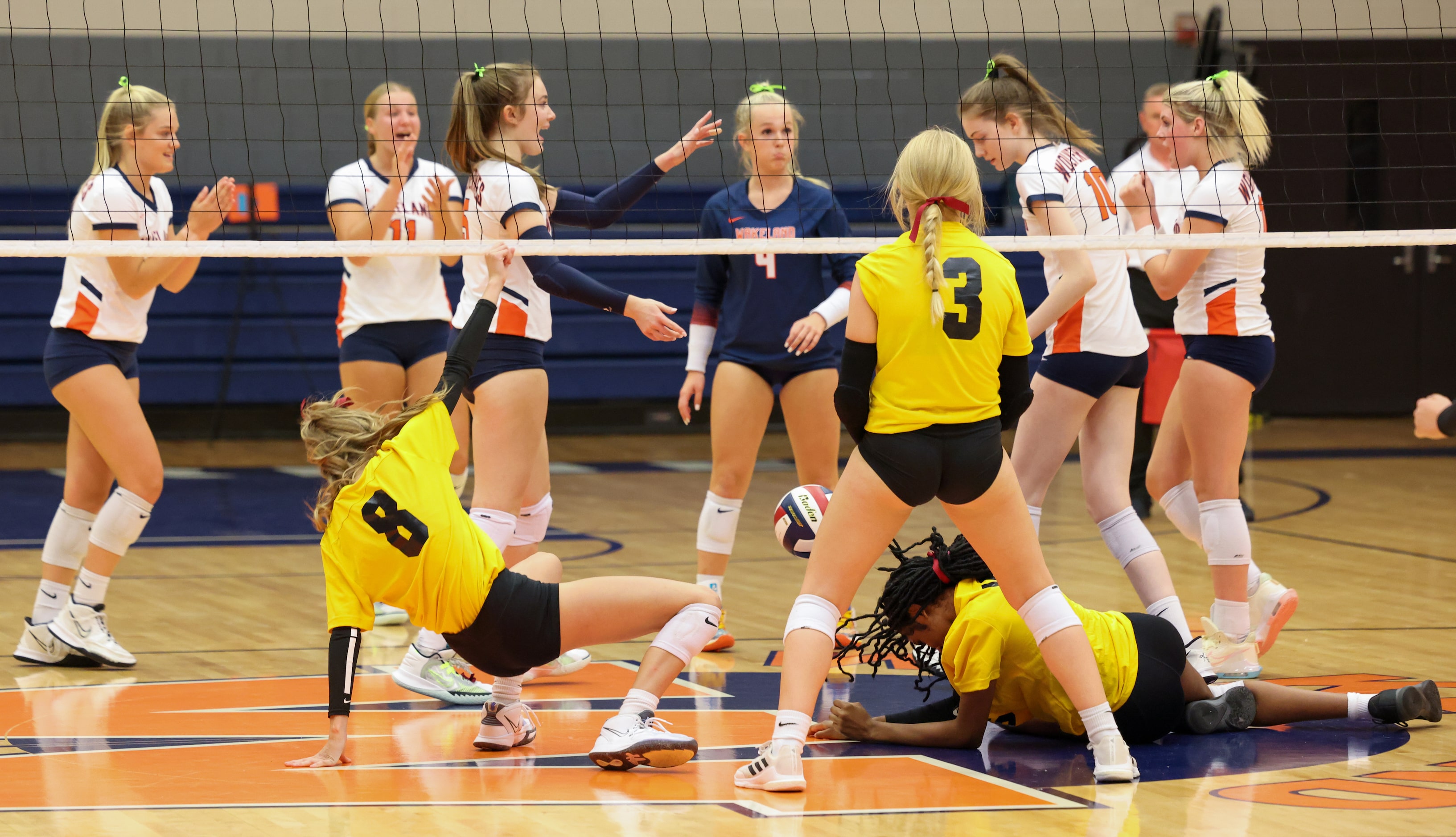 Frisco ISD’s Memorial High School volleyball players fall to the ground in the first set of...