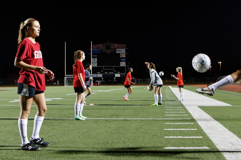 Coppell Cowgirls teammates Tara Vishnesky (left) and Grace Vowell, both seniors, pass a ball...