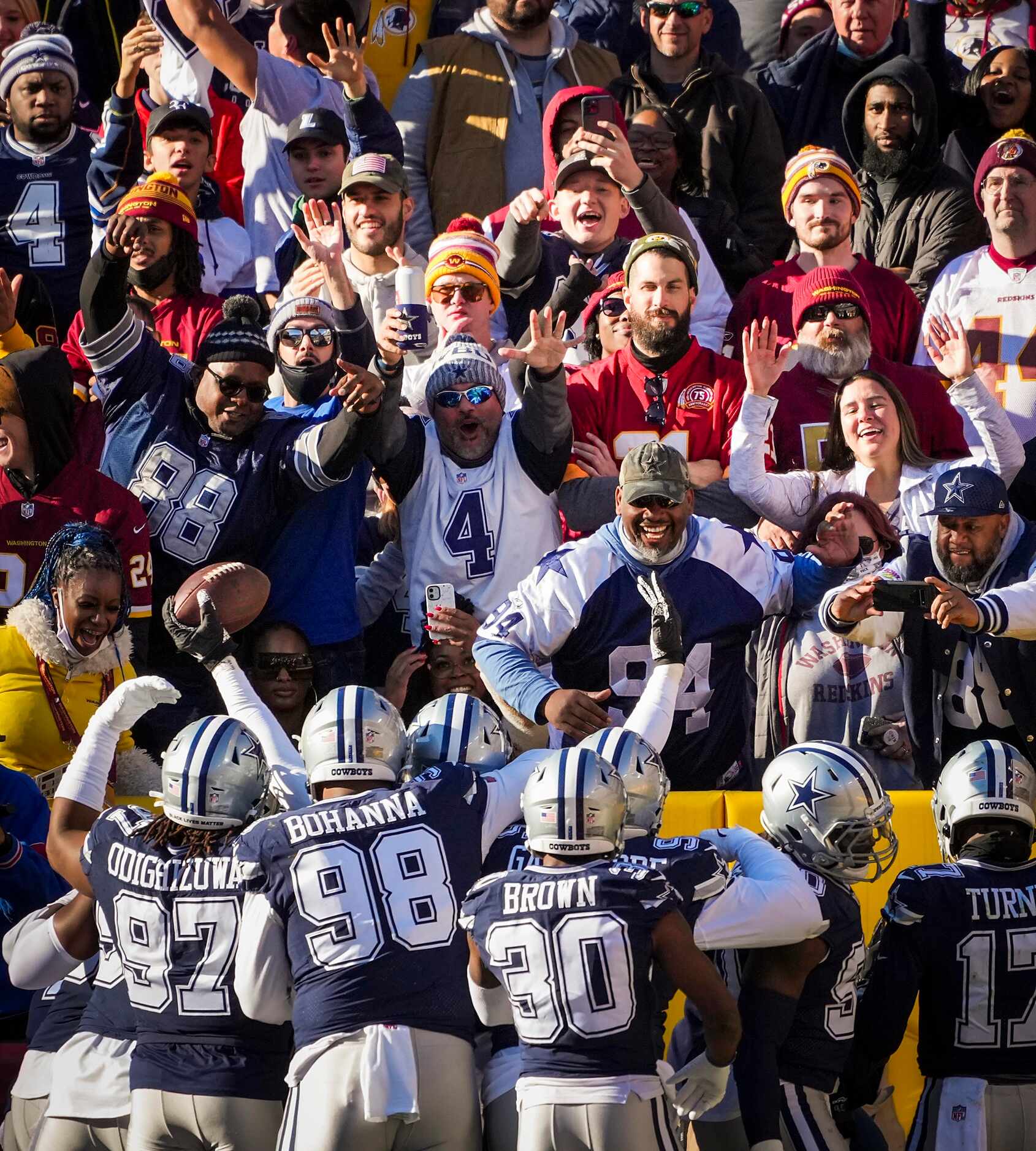 Fans cheer as Dallas Cowboys players celebrate around defensive end Dorance Armstrong after...