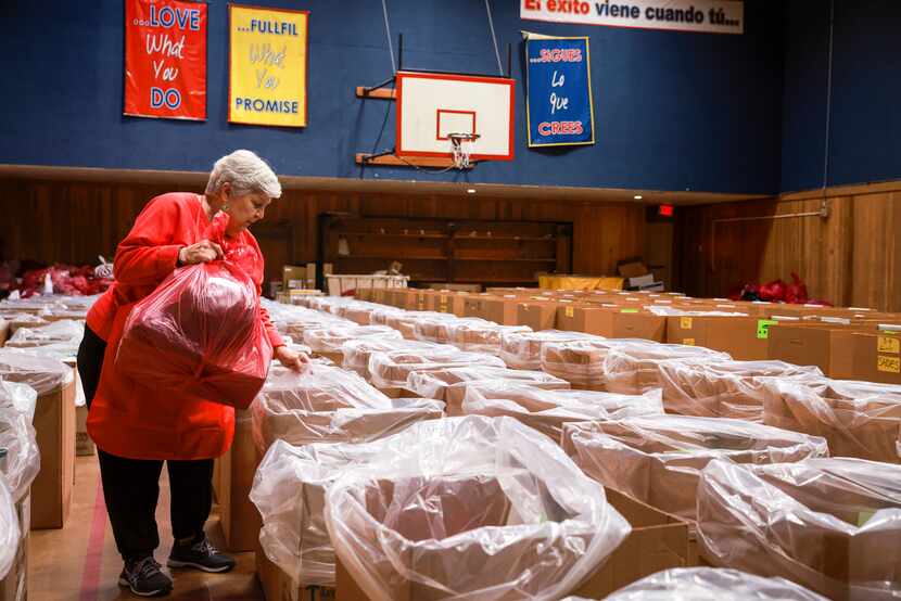 Estella Potsches sorts holiday gifts into the sea of boxes, each designated for a particular...