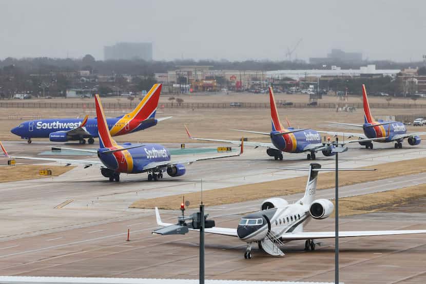 Southwest Airlines planes wait in line to take off from the Dallas Love Field Airport in...