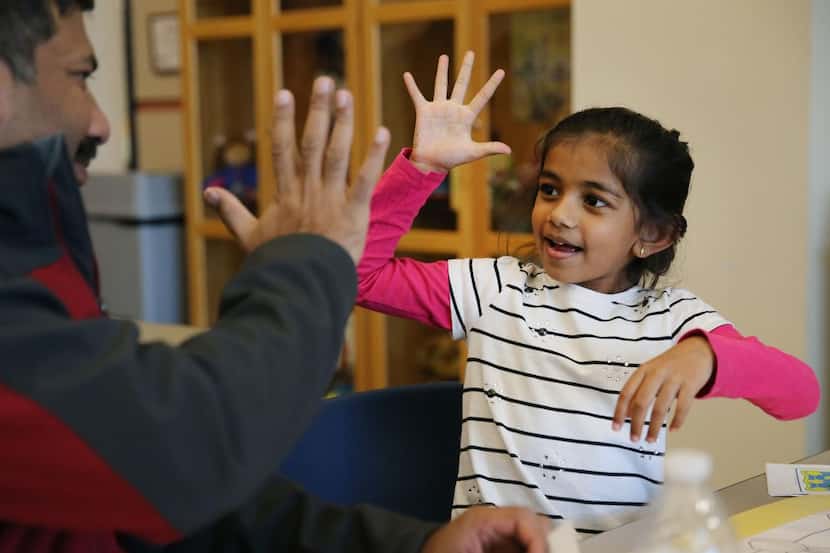 This file photo from 2019 shows Anoshka Mody giving a high-five to her father, Chandan Mody,...