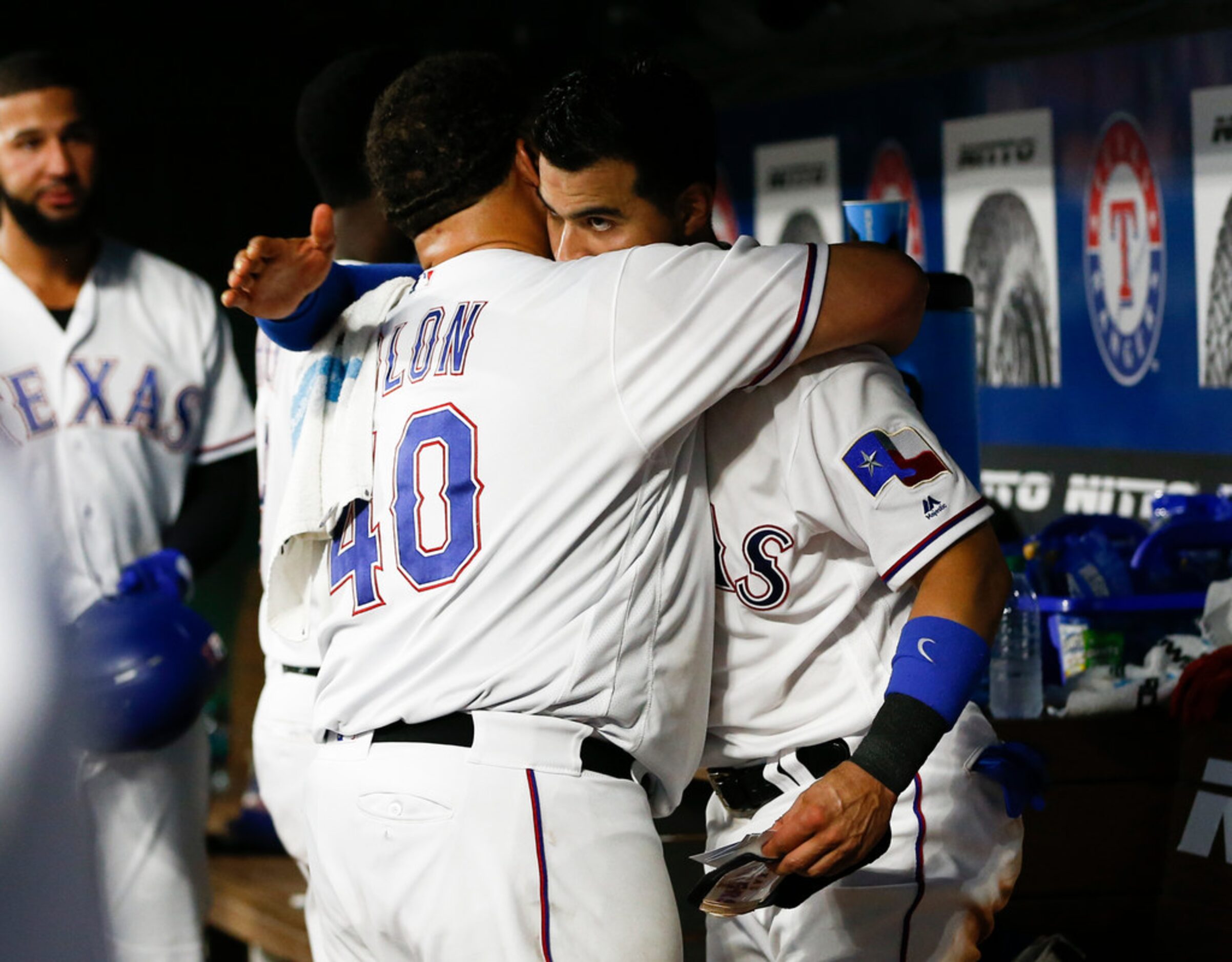 Texas Rangers' Bartolo Colon (40) is embraced by Robinson Chirinos, right, as he arrives in...