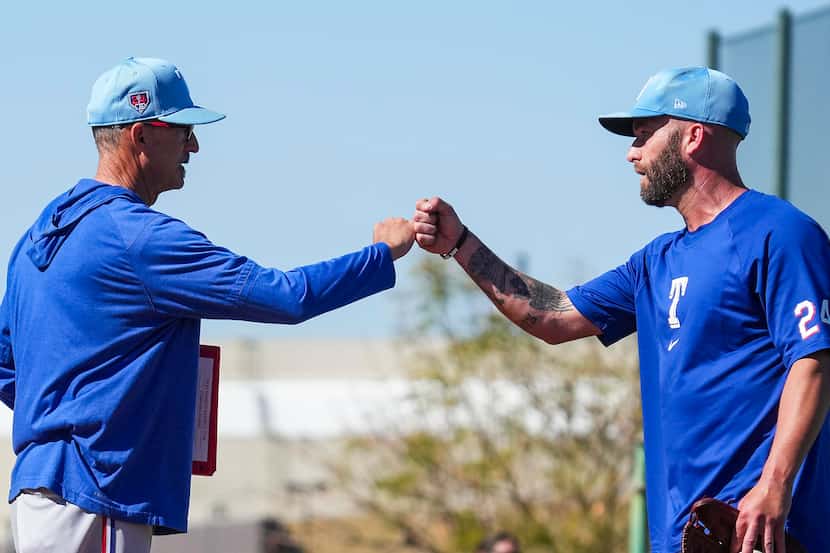 Texas Rangers pitcher Danny Duffy fist bumps pitching coach Mike Maddux after throwing in...
