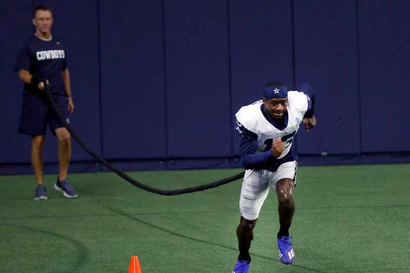 Dallas Cowboys associate athletic trainer Britt Brown works with wide receiver Michael...