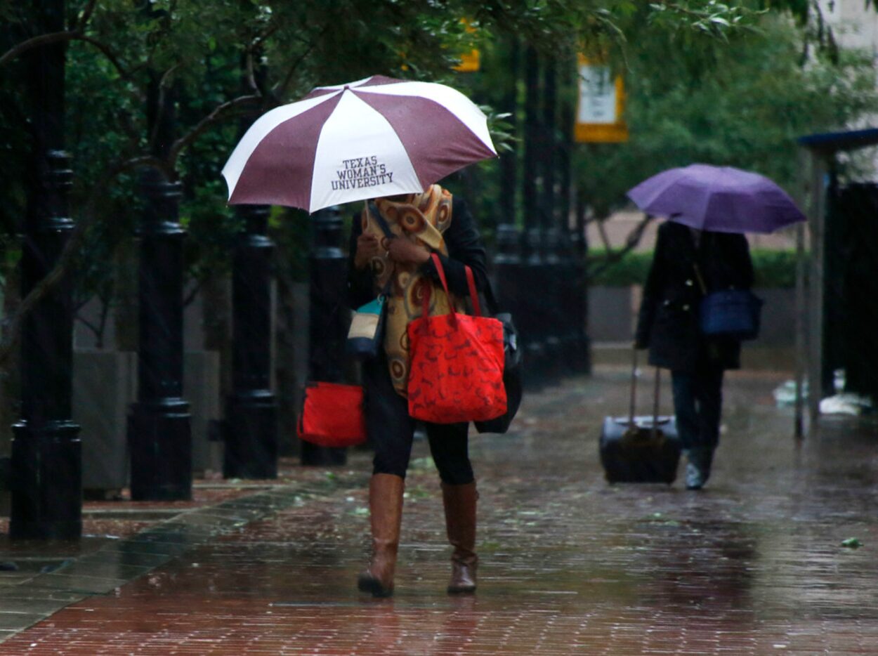 People make their way through wet and cold conditions as temperatures dropped into the 40s...