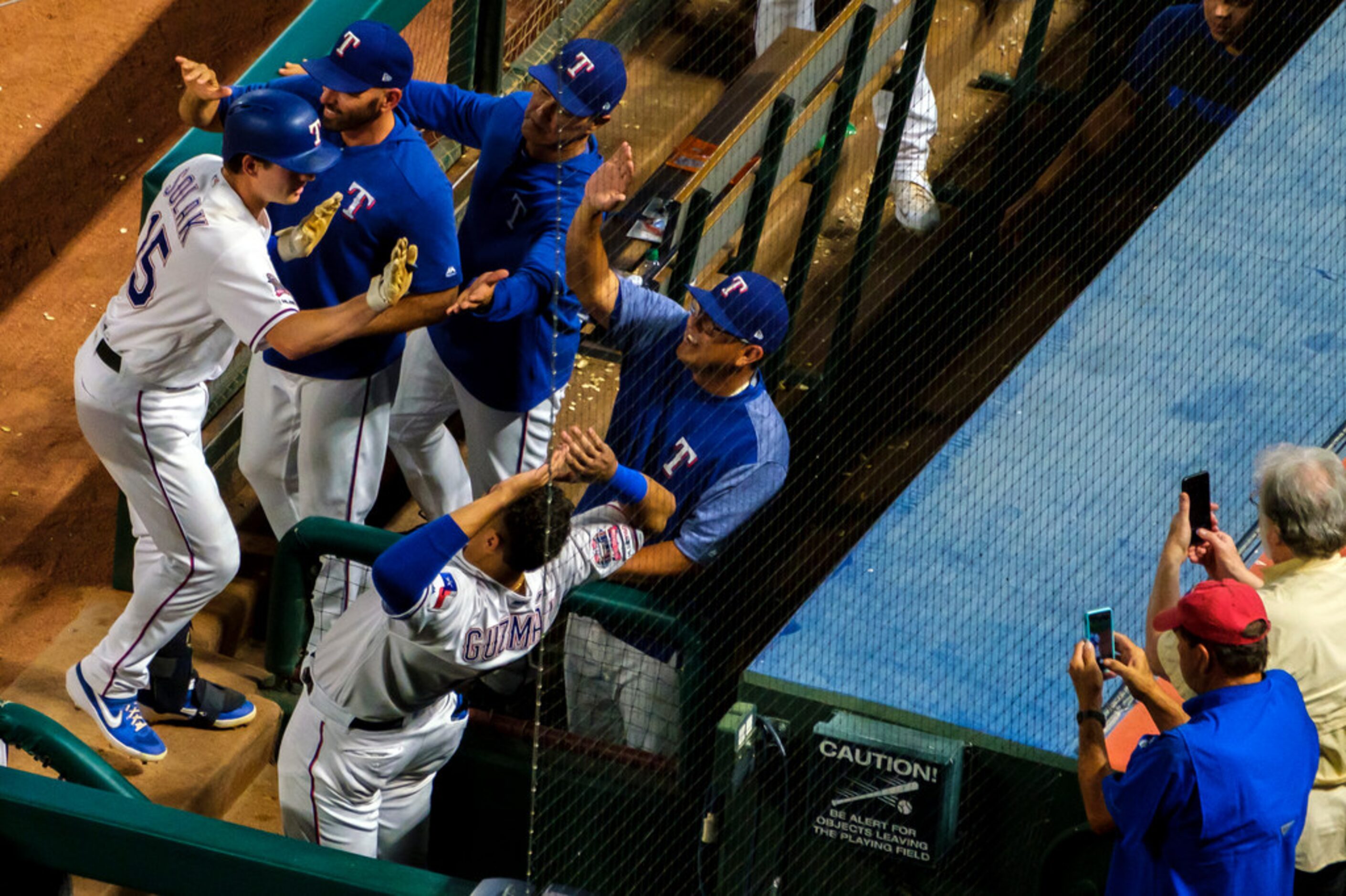 Texas Rangers designated hitter Nick Solak (15) is congratulated as he returns to the dugout...