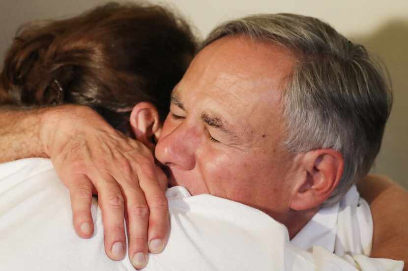 Texas Gov. Greg Abbott  hugs a woman following a vigil for victims at St Pius X Church after...