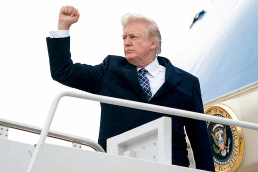 El presidente Donald Trump saluda con un puño al abordar el avión presidencial en la base...