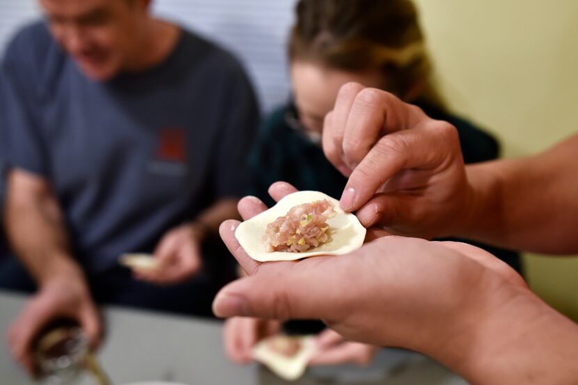 Will Chi forms a pork dumpling as friends and family make dumplings from scratch during a...