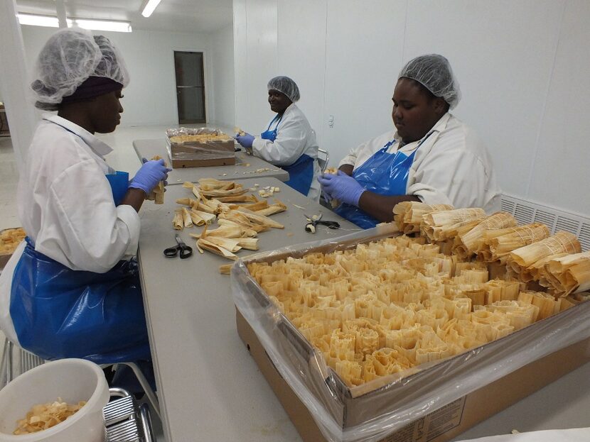 Workers at Hot Tamale Heaven in Greenville prepare tamales for sale, trimming the corn husks...