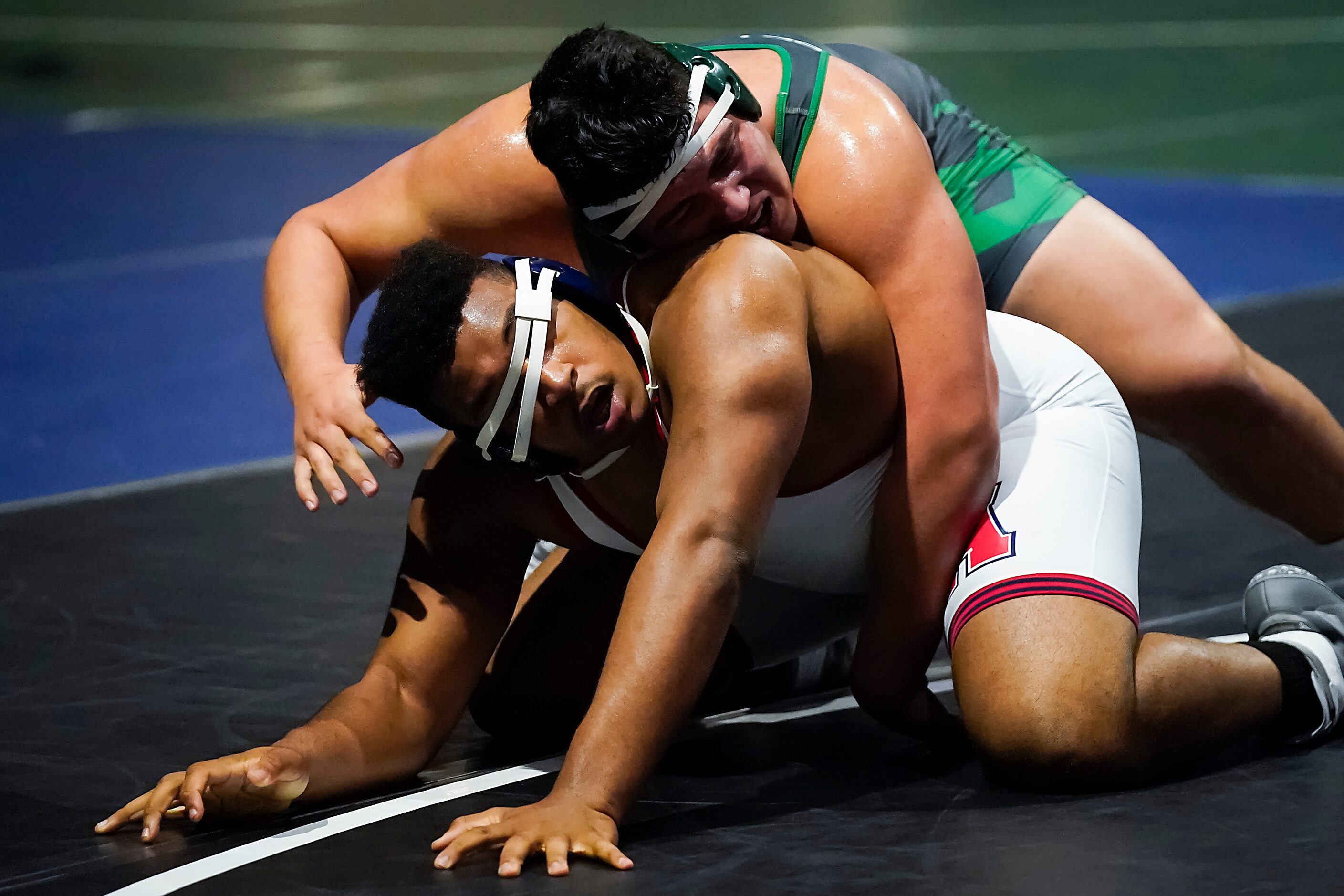 Emmett Bivens of Allen (bottom) wrestles Ivan Escobar of El Paso Montwood for the 6A boys...