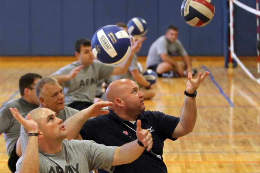 USA Sitting Volleyball Coordinator Elliot Blake (center) demonstrated a proper serve as...