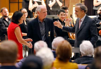 The Orchestra of New Spain music director Grover Wilkins III (center) is honored by the...