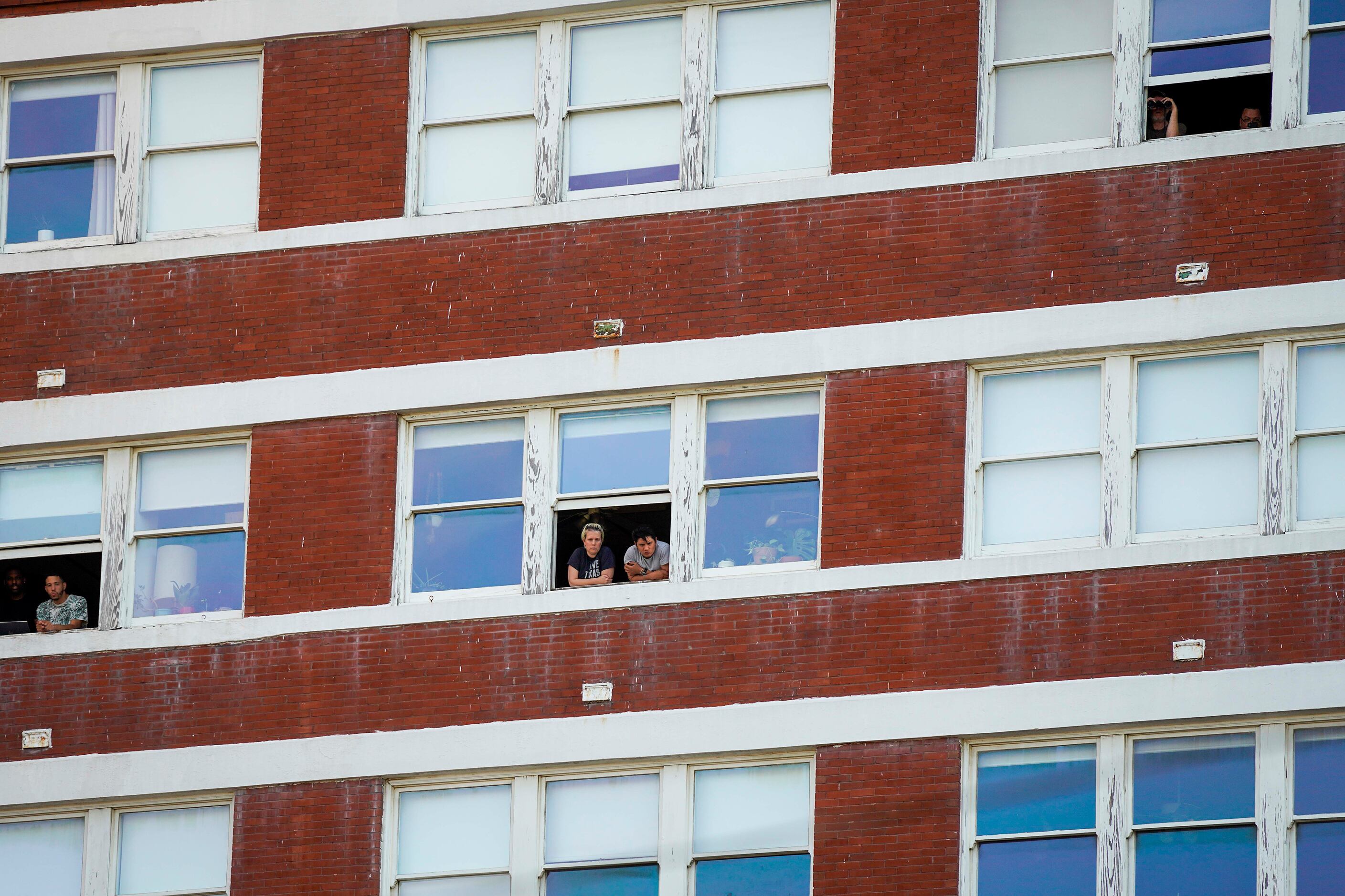People watch from the windows of South Side on Lamar during protest against police brutality...