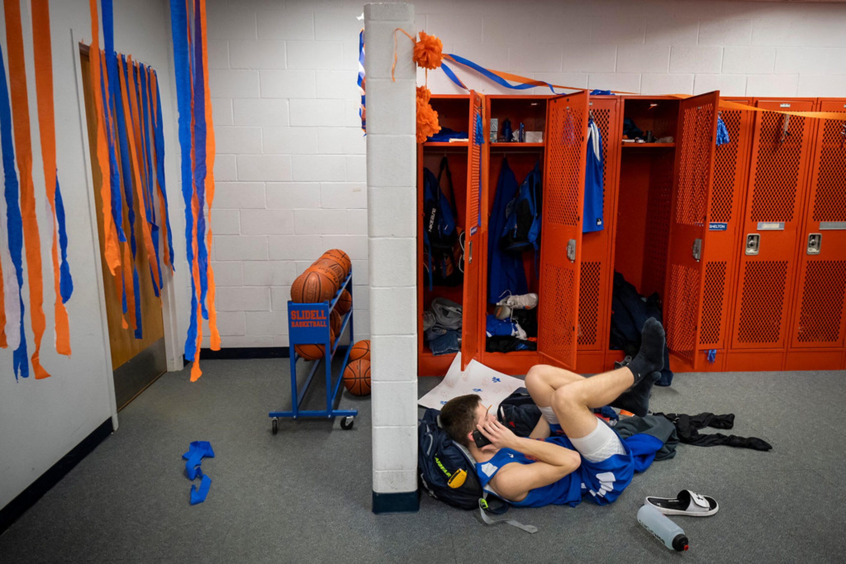 Steamers decorate the basketball lockerroom as Slidell center Brady Vanover makes a phone...