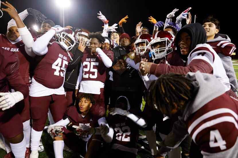 Red Oak players celebrate their overtime win against Denton Ryan in the first round of the...