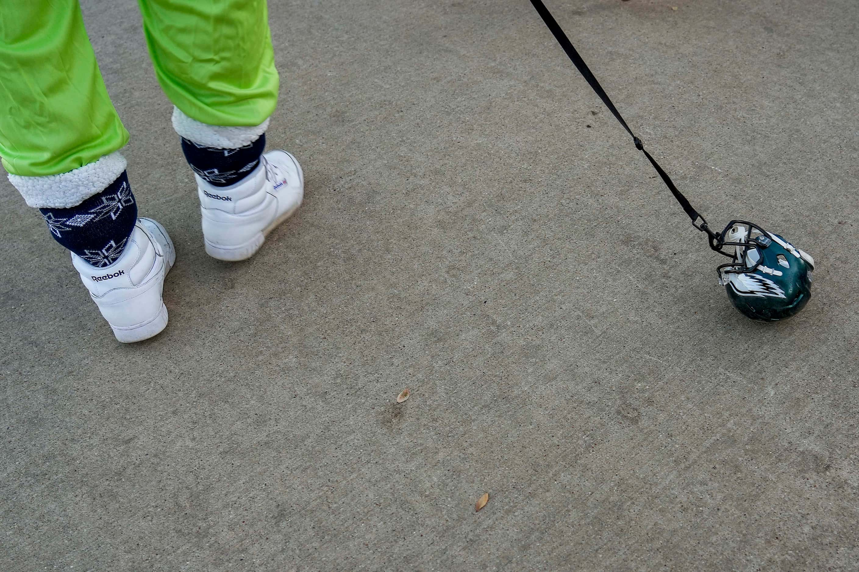 A Dallas Cowboys drags a Philadelphia Eagles helmet on a leach while tailgating before an...