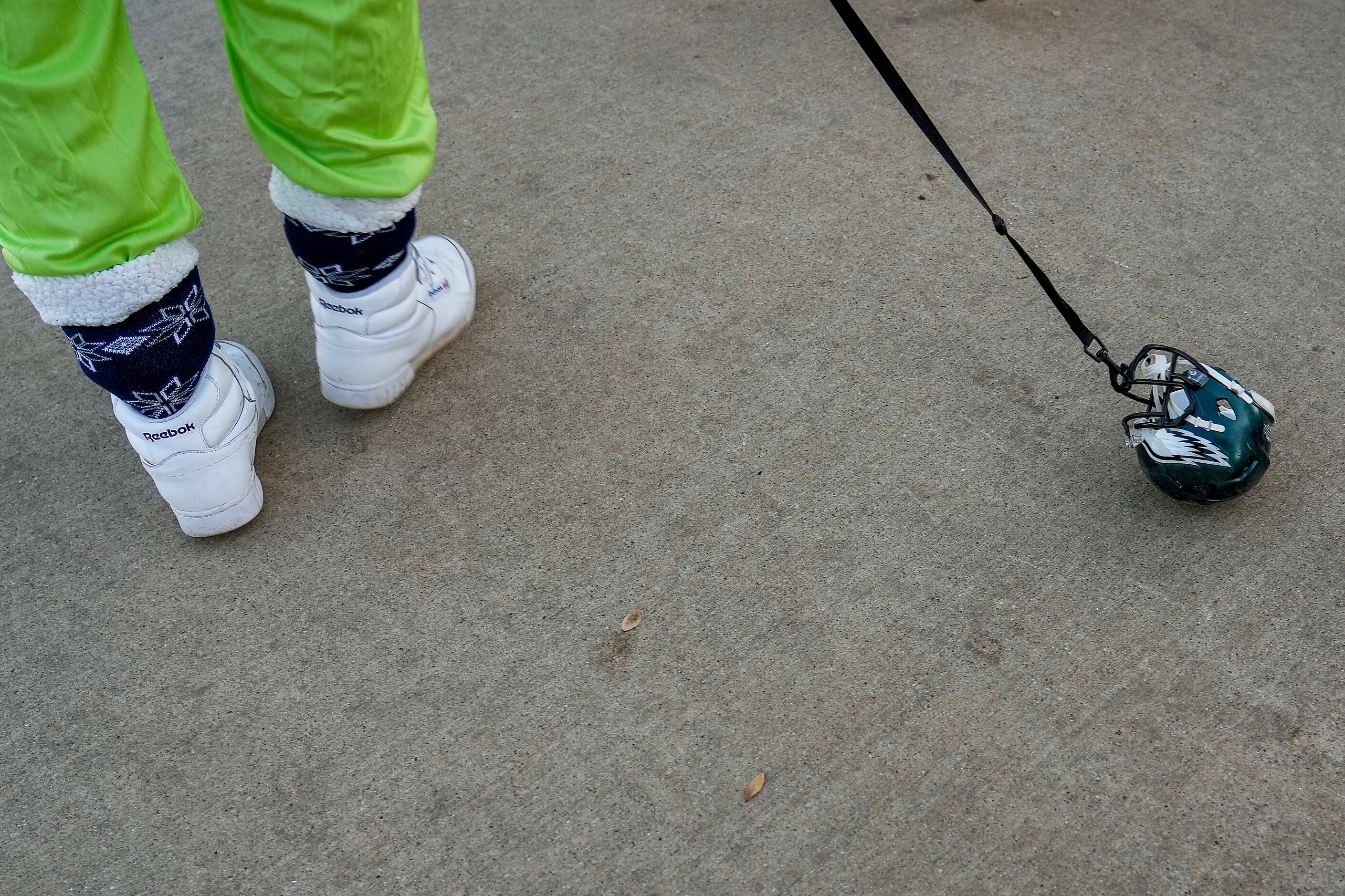 A Dallas Cowboys drags a Philadelphia Eagles helmet on a leach while tailgating before an...