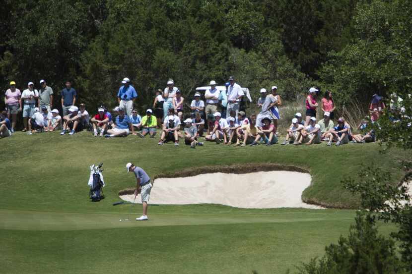 Spectators watch as Highland Park's Cash Carter attempts a putt on the second hole during...