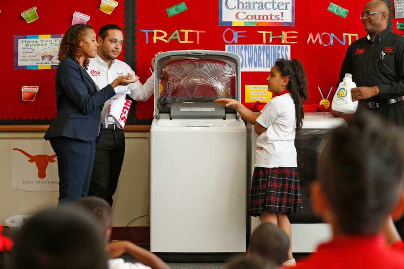 Marna Alisawi, 9, learns how to use a washing machine with a little help from gifted and...