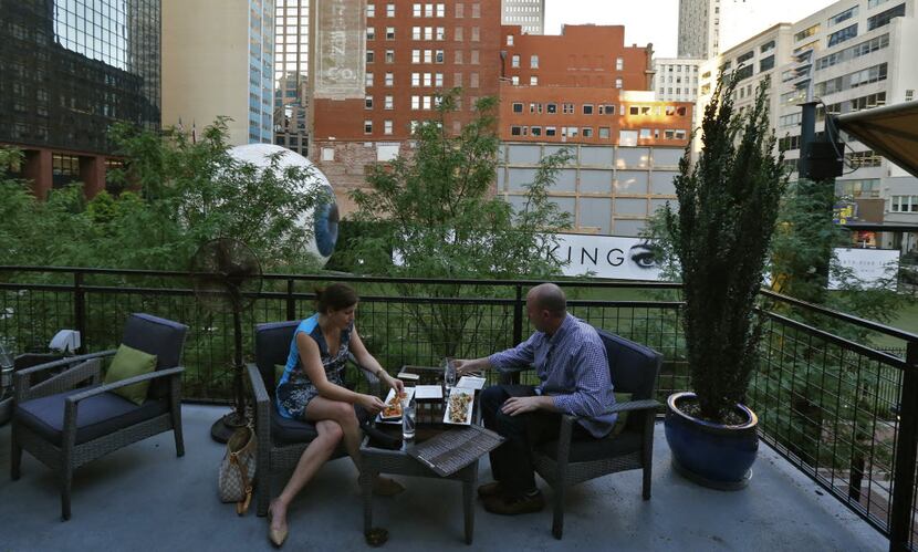 Cami Sharp (left) and Brady Phillips eat on the patio of The Woolworth restaurant and patio. 