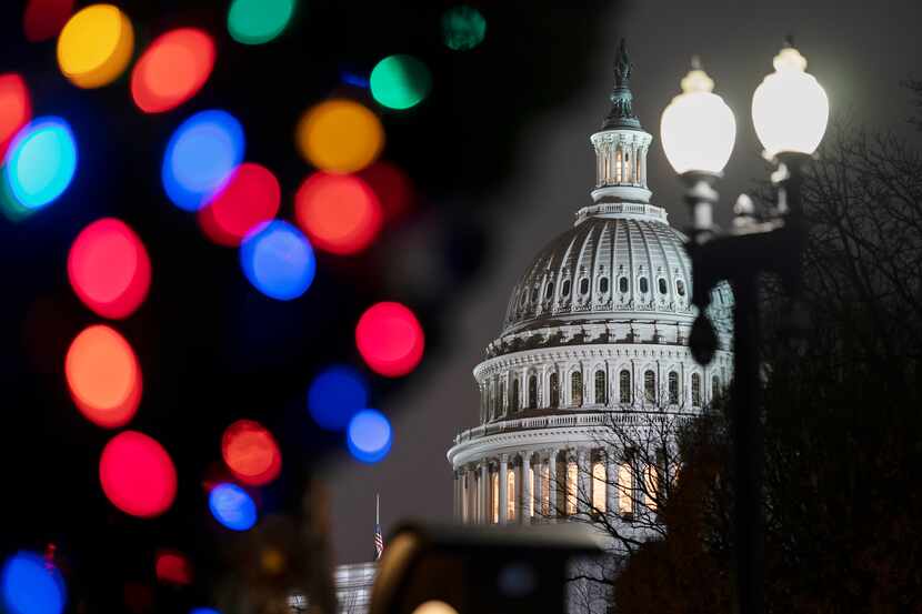 La imagen muestra al Capitolio en Washington con luces navideñas. La Cámara de...
