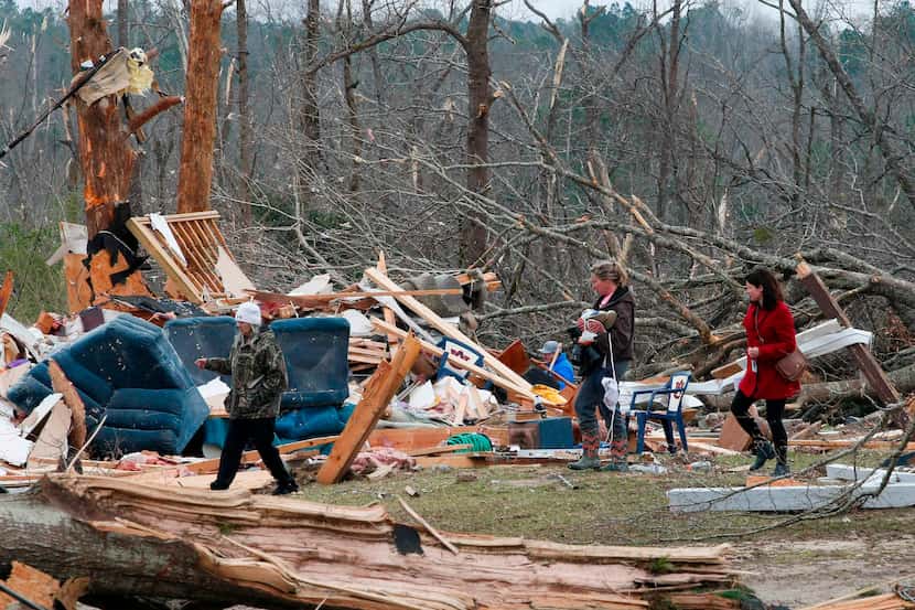 Residents looked for belongings this week at a home after it was destroyed in a tornado in...