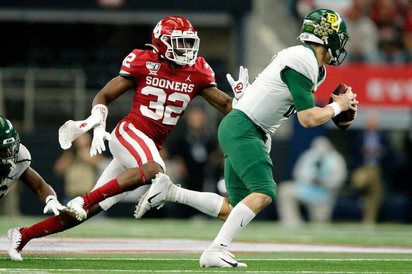 Baylor Bears quarterback Charlie Brewer (12) is chased from the pocket by Oklahoma Sooners...