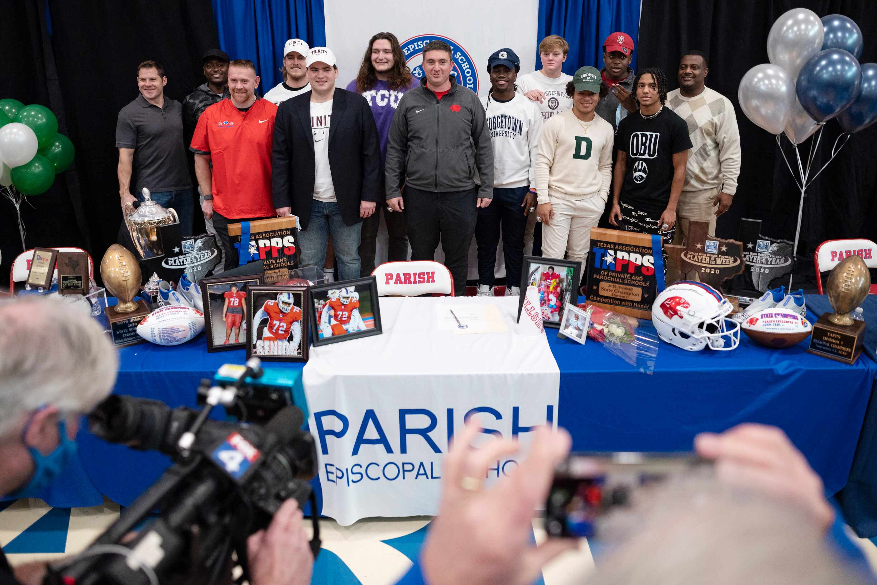 Parish Episcopal head football coach Daniel Novakov, center, stands with members of his...