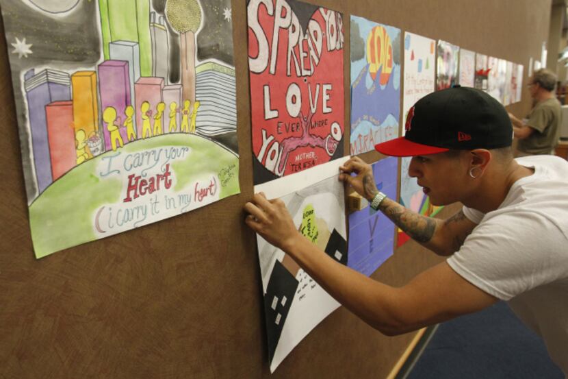 Volunteer Eduardo Morales installs art pieces as part of the Dallas Love Project at Dallas...