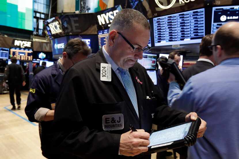 Trader John Yaccarine, center, works on the floor of the New York Stock Exchange Wednesday,...