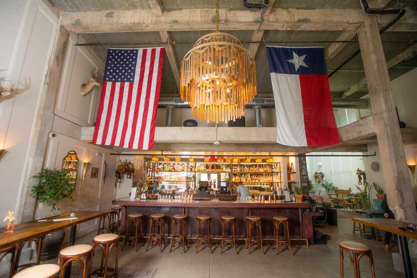 Upon entering, guests are greeted by American and Texan flags hanging over the bar at Side...