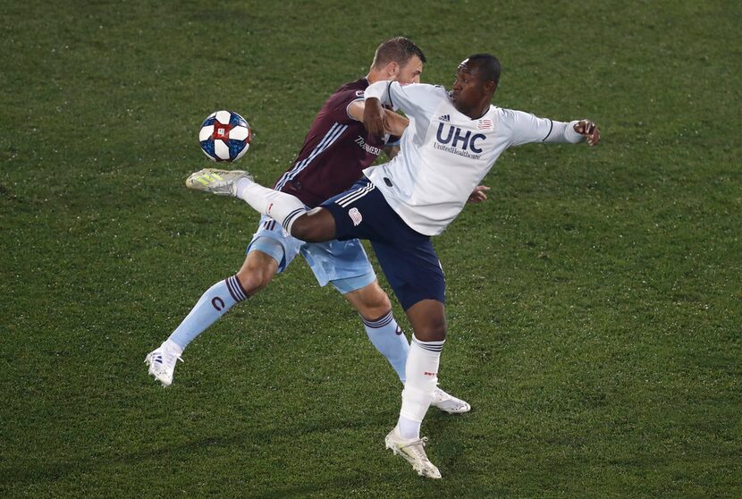 New England Revolution's Juan Caicedo, front, kicks the ball as Colorado Rapids' Tommy Smith...