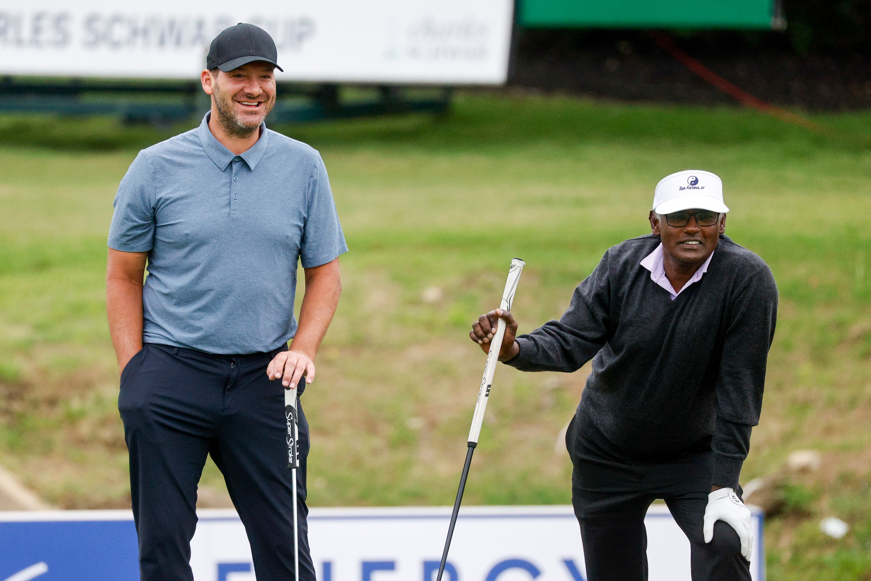 Former Dallas Cowboys quarterback Tony Romo talks with Vijay Singh on the 17th green during...