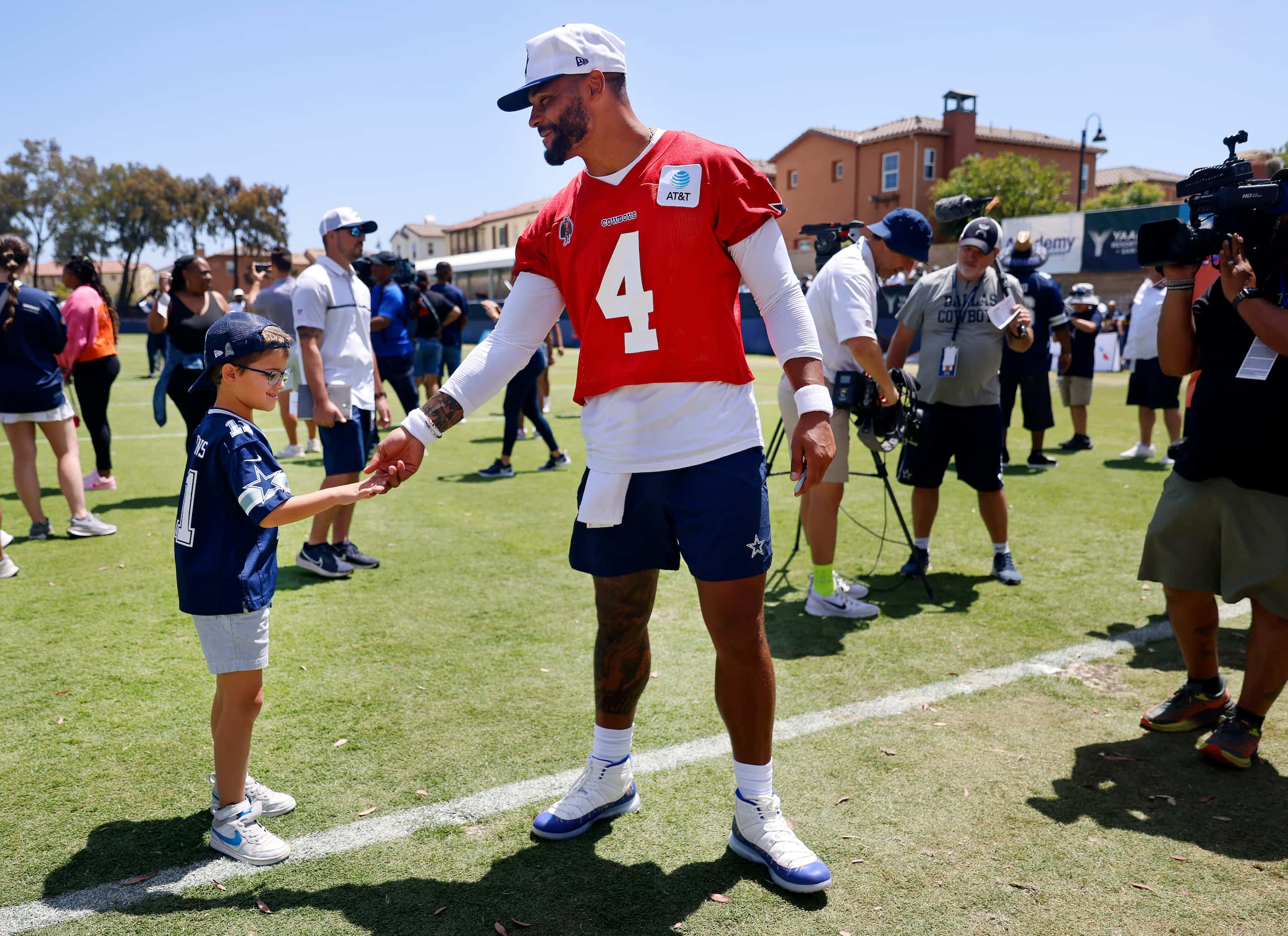Dallas Cowboys quarterback Dak Prescott (4) shakes hand with a young fan following a...