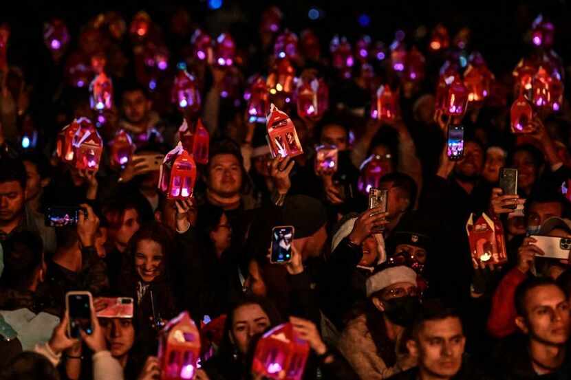Un grupo de gente sostiene velas durante la celebración de la noche de velitas, en Bogotá,...