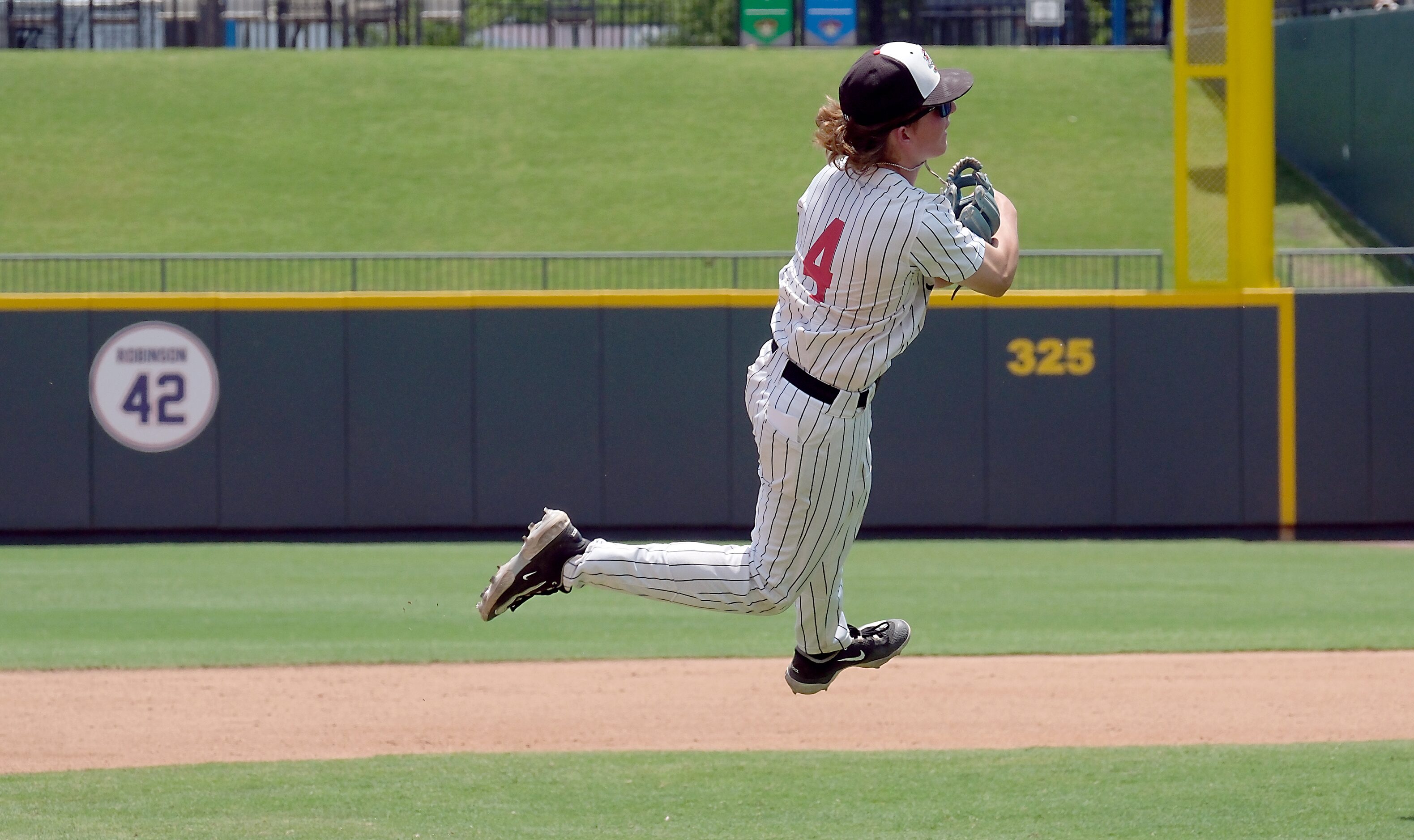 Argyle JC Davis, (4), floats in the air after attempting to get batter Magnolia West Jackson...