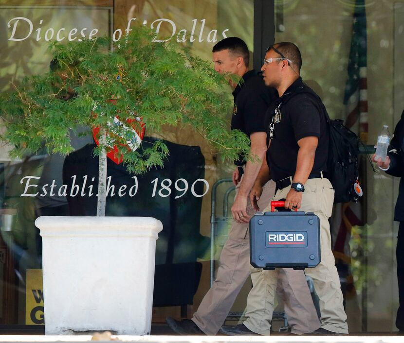 Law enforcement officials worked Wednesday at the offices of the Catholic Diocese of Dallas.