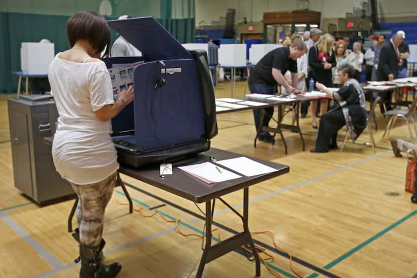Samantha Heard casts her votes using an electric voting machine at Reverchon Park Recreation...