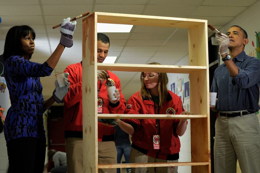 President Barack Obama and first lady Michelle Obama stain a bookshelf at Burrville...