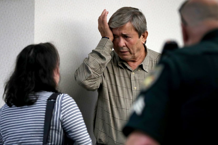 Antonios Pagourtzis, center, wipes away tears next to his wife, Rose Marie Kosmetatos, left,...