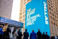 Onlookers at the AT&T Discover Center look up at the towering media wall showing the new...