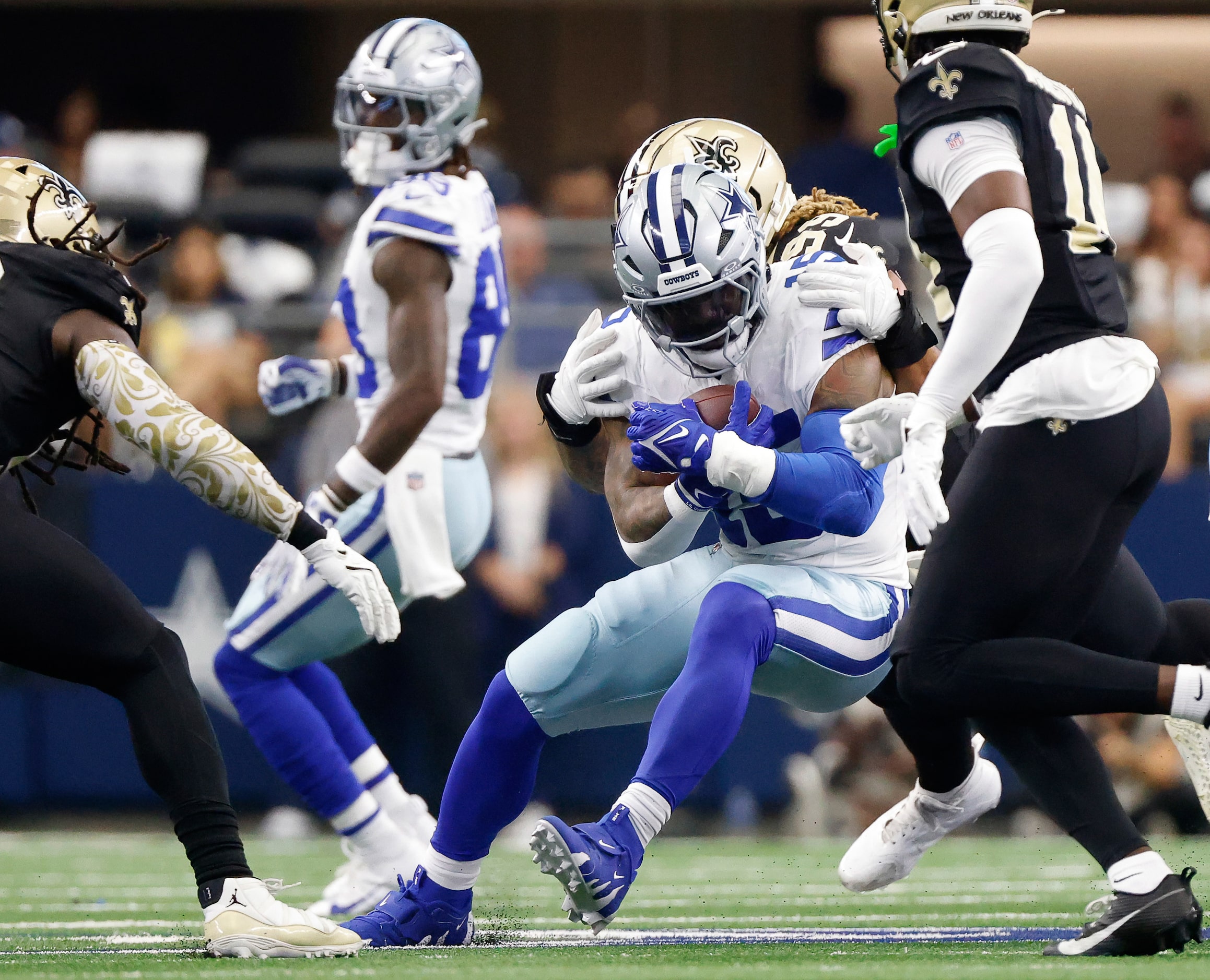 Dallas Cowboys running back Ezekiel Elliott (15) is wrapped up near the line of scrimmage by...