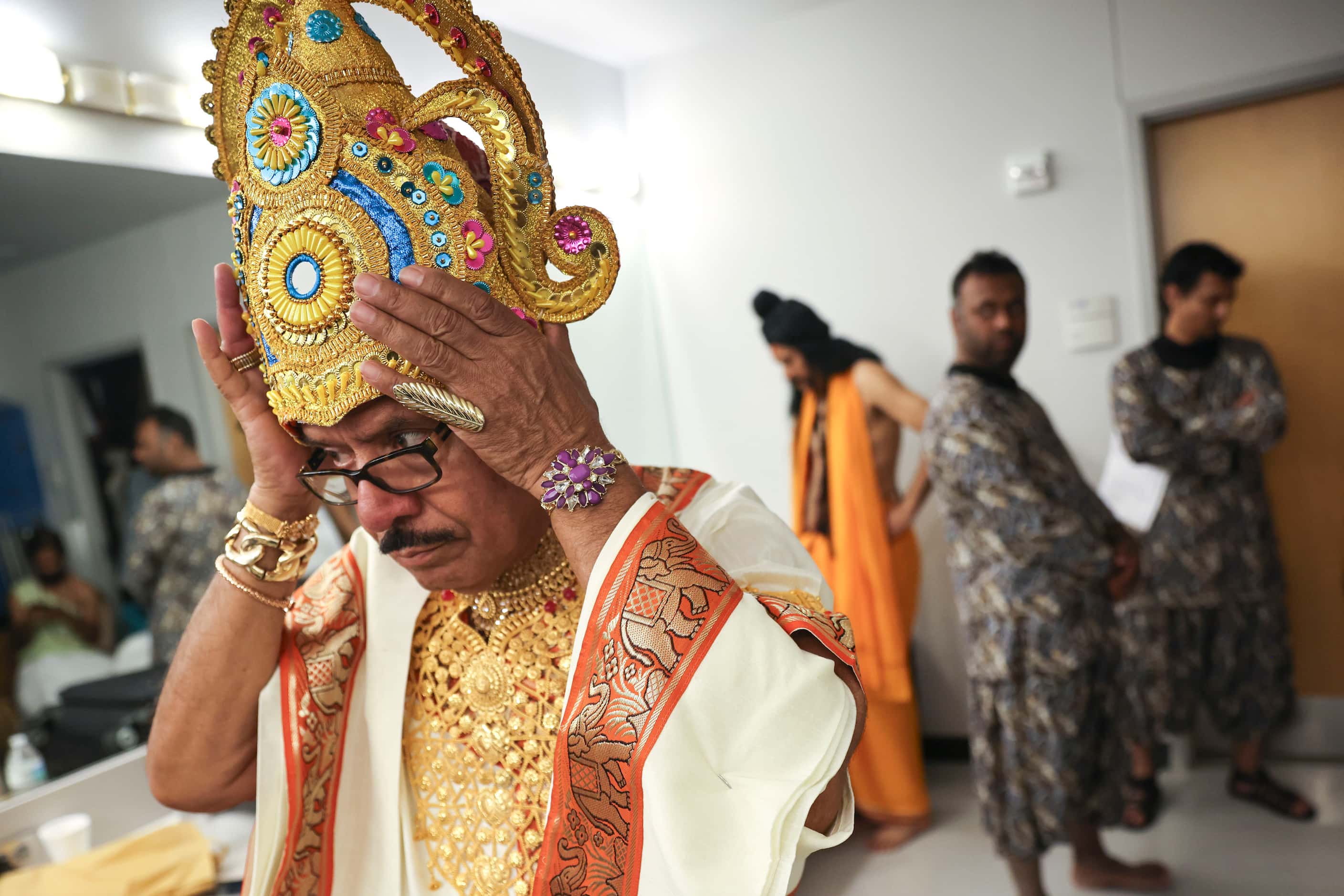 Cast members Md Mohiuddin, playing the role of Indra, puts on his Mukut (crown), as he...