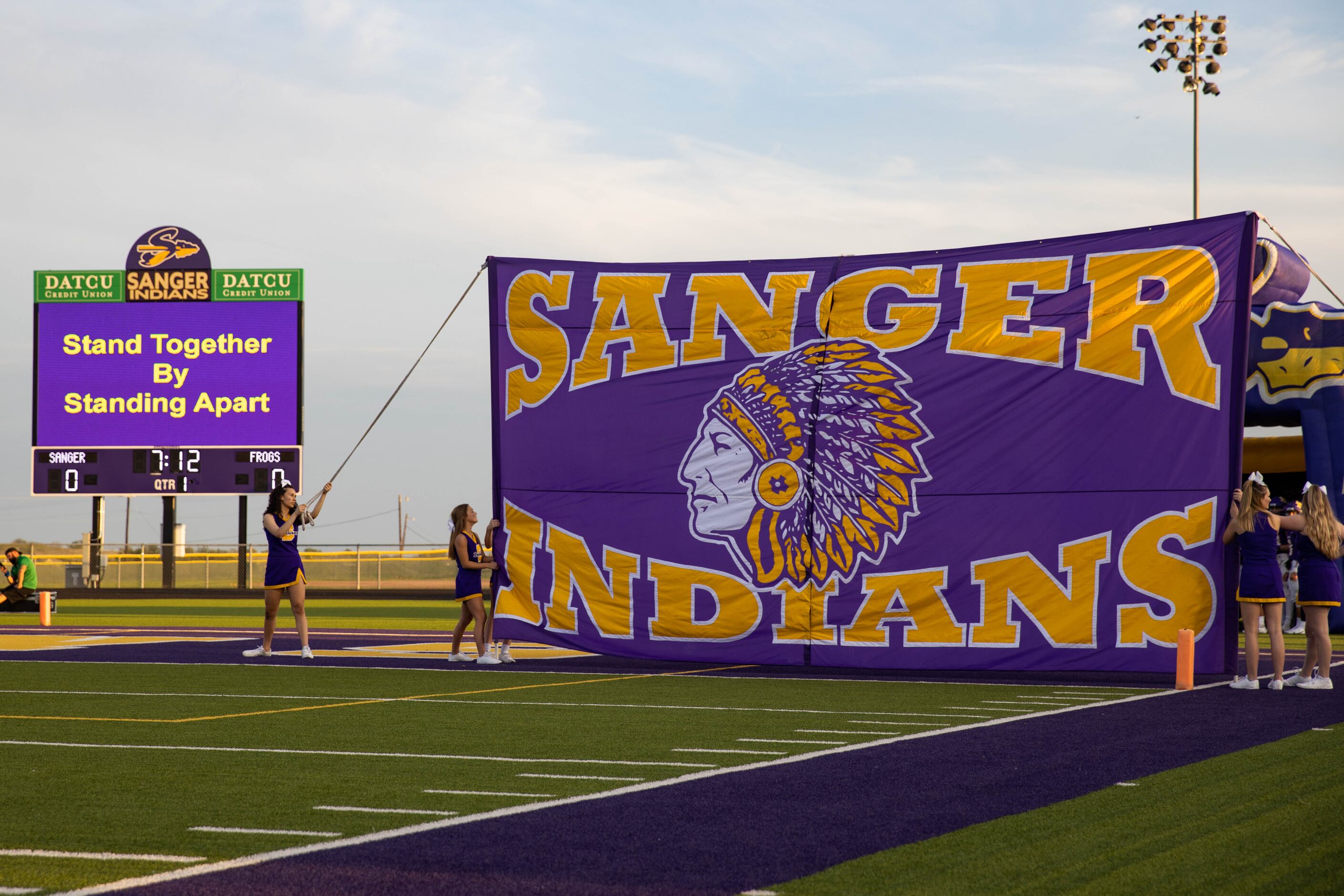 Sanger High School cheerleaders holds a banner before the start of a game against Lake Worth...